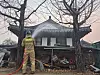 A fire fighter spray water on a traditional house in Hahoe Folk Village in Andong, North Gyeongsang as a preventive measure on March 26. [JOONGANG ILBO]