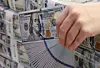 A bank representative holds U.S. dollars at a Hana Bank branch in central Seoul on Nov. 5. [YONHAP]