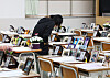 A person looks at photos of victims of the Sewol ferry tragedy at a classroom of Danwon High School in Ansan, Gyeonggi, on Monday. Tuesday marks the 10th anniversary of the tragedy, where 304 passengers and crew died after the Sewol ferry capsized off the coast of Jindo, South Jeolla, on April 16, 2014, while en route to Jeju Island. Of those who died on the ferry, 250 were juniors from Danwon High School. [YONHAP]