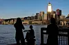 Tourists relax by the Victoria Harbour waterfront, with the iconic skyline providing a scenic backdrop, in Hong Kong on July 10, 2023. [REUTERS/YONHAP]