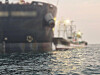 A cargo ship, left, and a fishing boat remain lodged together after a collision on May 26. [COAST GUARD]