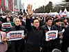 Conservative People Power Party (PPP) Rep. Kim Gi-hyeon, center, raises his hands into the sky in prayer at a rally in Yeouido, western Seoul, on March 1. PPP Rep. Choo Kyung-ho, left, holds up a placard that says ″Please Save Korea.″ [NEWS1]