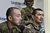 Chinese nationals Zhang Renbo, left, and Wang Guangjung, right, look on during a press conference in Kyiv on April 14. Zhang and Wang were captured by Ukrainian forces in the Donetsk region during what they claimed to be their first combat mission on the frontline. [AFP/YONHAP]