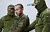 Servicemen of Security Service of Ukraine (SSU) escort Chinese national Zhang Renbo upon his arrival to attend a press conference in Kyiv on April 14. [AFP/YONHAP]