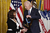 U.S. President Joe Biden, right, talks with Victoria Secrest, as he presents the Medal of Honor, the nation's highest military decoration, posthumously to her father, Corporal Fred McGee, during a ceremony in the East Room of the White House in Washington on Jan. 3. [AP/YONHAP]