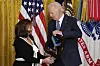 U.S. President Joe Biden, right, talks with Victoria Secrest, as he presents the Medal of Honor, the nation's highest military decoration, posthumously to her father, Corporal Fred McGee, during a ceremony in the East Room of the White House in Washington on Jan. 3. [AP/YONHAP]