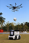 A drone passes a package to an unmanned autonomous robot in Yeosu, South Jeolla, during a demonstration Tuesday. [GS CALTEX]