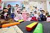 Children learn to play yut, a traditional Korean game which is enjoyed during the Chuseok Holidays, at a preschool in Incheon on Thursday. [YONHAP]