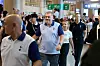 Tottenham Hotspur manager Ange Postecoglou, center, smiles as he walks through the terminal. [COUPANG PLAY]
