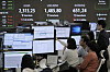 Currency traders watch monitors near a screen showing the Korea Composite Stock Price Index, top left, and the foreign exchange rate between dollar and Korean won, top center, at the foreign exchange dealing room of the KEB Hana Bank headquarters in central Seoul on April 9. [AP/YONHAP]