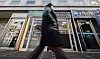 A pedestrian walks past ATMs of Korea's major banks in central Seoul on Jan. 12. [YONHAP]
