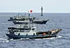 Chinese fishing vessels navigate past a beacon in the Zhubi Reef off Spratly Islands in South China Sea, July 18, 2012. [AP/YONHAP]