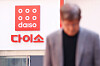A passerby walks past a Daiso sign hanging on the store in Seoul on April 15, 2025. [YONHAP]