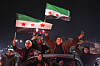 People celebrate as Syrian government troops take control of the town from the Syrian Democratic Forces (SDF) in Raqqa, northeastern Syria, on Jan. 18. [AP/YONHAP]