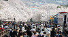 Crowds walk under cherry blossom trees in full bloom at Gyeonghwa Station Park in Jinhae, South Gyeongsang, on Sunday, even though the annual cherry blossom festival was canceled again this year because of the Covid-19 pandemic. Local authorities did not block visitors from coming to the park this year. [YONHAP]