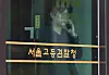 A person talks on the phone behind the doors of the Seoul High Prosecutors’ Office in Seocho District, southern Seoul, where the special counsel team investigating the martial law allegations is based, on June 26. [YONHAP]