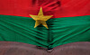 The Burkina Faso nationals flag with a man standing in front of it is seen during a memorial ceremony in Ouagadougou, Burkina Faso on Jan. 23, 2016. [AP/YONHAP]