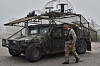 A Ukrainian soldier passes by an armoured Hummer vehicle equipped with an anti-drone net on the frontline in the Zaporizhzhia region, Ukraine, on May 5. [AP/YONHAP]