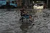 A boy pushes his cousin on wheelchair through a flooded road caused by heavy monsoon rains, in Lahore, Pakistan, Sunday, June 29. [AP/YONHAP]