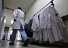 A doctor walks by a hanger with doctors' white gowns at a general hospital in Daegu in March 2024. [YONHAP]