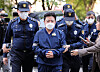 Police officers escort Ra Deok-yeon, who was indicted for stock price manipulation, at the Seoul Southern District Court in Yangcheon District, western Seoul, on May 11, 2023. [NEWS1]