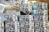 An employee arranges stacks of dollar bills at Hana Bank's Counterfeit Notes Response Center in Jung District, central Seoul, July 3.[NEWS1]