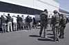 This image from video provided by U.S. Immigration and Customs Enforcement via Dvids shows manufacturing plant employees waiting to have their legs shackled at a joint battery factory operated by Hyundai Motor Group and LG Energy Solution in Ellabell, Georgia, on Sept. 4. [AP/YONHAP]
