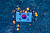 Haenyeo, or female divers, from Jeju and Ulleung islands hold up a large Taegeukgi, or Korean national flag, after performing a diving demonstration off Dokdo on Aug. 8. [JEJU PROVINCIAL GOVERNMENT]
