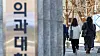 Students walk by a medical school gate in Seoul on March 28. [NEWS1]