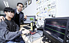 Han Dong-guk, a professor at Kookmin University's Department of Information Security, Cryptography and Mathematics, performs an experiment with a student at the university lab. [JOONGANG ILBO]