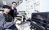 Han Dong-guk, a professor at Kookmin University's Department of Information Security, Cryptography and Mathematics, performs an experiment with a student at the university lab. [JOONGANG ILBO]