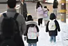 Children carefully walk down a slope near an elementary school in Seodaemun District, western Seoul, as snow falls on Feb. 2. [YONHAP]