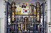 Bang In-cheol, a professor in Unist’s Department of Nuclear Engineering, holds the Korean flag in front of Patriot, a unique experimental device that serves as an eighth-scale model of the APR1000 reactor, located inside the Specialized Experiment Building at Ulsan National Institute of Science and Technology. [JOONGANG ILBO]