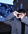 Former Tottenham Hotspur player Son Heung-min poses with his signature camera clicking hand gesture in front of a mural outside of the Totthenham Hotspur Stadium in London in this screen capture from Tottenham Hotspur's Instagram. [SCREEN CAPTURE]