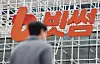 The Bithumb company logo is seen as a pedestrian walks by the Bithumb Lounge in Gangnam District, southern Seoul, on Feb. 12. [NEWS1]