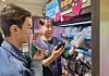 A CU employee and a customer utilize the convenience store’s AI-powered translation service using the Personal Digital Assistant. [CU]