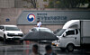 Officials walk through the main gate of the National Information Resources Service headquarters in Daejeon on Oct. 13. [JOONGANG ILBO]