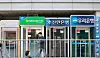 Pedestrians pass by ATMs from firms including KB Kookmin Bank and Woori Bank in Seoul on April 27. [YONHAP]