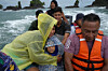 Venezuelan Mariela Gomez holds her son Mathias as they make their way to shore after arriving on a larger cargo vessel in Jaque, on Panama's Pacific coast, during their journey south after giving up on reaching the United States, on Sept. 18. [AP/YONHAP]