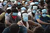 People from China, Vietnam and Ethiopia, believed to have been trafficked and forced to work in scam centers, sit with their faces masked while in detention after being released from the centers in Myawaddy district in eastern Myanmar, on Feb. 26. [AP/YONHAP]