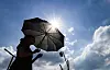 As the heat wave warning continues in Daegu on July 23, a person walks with a parasol at Dongdaegu Station Plaza. [YONHAP]