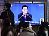A live broadcast of President Lee Jae Myung delivering a policy briefing to the Ministry of Health and Welfare airs on televisions in the main concourse of Seoul Station in Yongsan District, central Seoul, on Dec. 16. [NEWS1]
