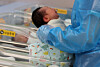 A nurse looks over a newborn at a nursery room at CHA Ilsan Medical Center in Goyang, Gyeonggi, on Nov. 26. [YONHAP]