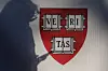 A pedestrian casts a shadow on a Harvard University sign after U.S. President Donald Trump said that his administration was close to a deal with Harvard University, in Cambridge, Massachusetts, Sept. 30. [REUTERS/YONHAP]