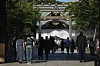 A woman and a man bow in front of the main hall of Yasukuni Shrine in Tokyo on Aug. 15, 2024. [AP/YONHAP]