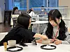 A Japanese student, left, helps a Korean student whisk matcha powder in a bowl during a cultural exchange session at Tezukayama Gakuin University in Osaka, Japan, on Jan. 22. [LEE SOO-JUNG]