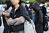 Commuters bundle up against the unseasonably early winter chill, with morning temperatures dropping to 4.8 degrees Celsius in Seoul, as they hurry through an intersection near Gwanghwamun on Oct. 21. [NEWS1]