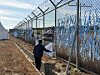 Park In-wook, 69, picks up litter around the fence area close to the runway of Muan International Airport in South Jeolla, where an airplane carrying his families crashed last year, on Dec. 22. [LEE SOO-JUNG]