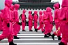 Performers dressed as 'Squid Game' (2021-25) soldiers march in a parade through central Seoul, followed by a fan event with the cast to celebrate the release of the third season of Netflix's hit series on June 28, 2025. [REUTERS/YONHAP]