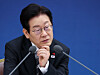 President Lee Jae Myung listens to ministry officials at a policy briefing at Sejong on Dec. 12. [YONHAP]